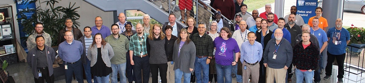 Malaking grupo ng iba't ibang tao, nakatayo sa malaking bintana sa Lobby ng headquarter ng mouser